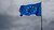 Europese vlag waait in de wind met donkere wolken op de achtergrond.