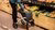 Old woman with walker grabs fruit in a supermarket.