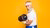 man lifting dumbell photographed from the side against a yellow background