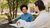 Two students chatting at picnic table on EUR campus