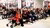 Gepensioneerden zitten in een zaal in Museum Overloon geboeid te luisteren naar een presentatie.