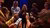 People standing in a circle and looking at each other while holding smarthone