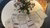 Different game components spread out on a white table next to a vase with flowers