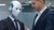 A humanoid robot in a suit with a person in a suit
