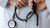 A female doctor holds a stethoscope behind her back