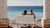 Couple sitting on a bench overlooking the ocean.