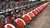 Row of red rental bicycles lined up on a city sidewalk
