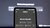 Phone displays virtual assistant prompt ‘What can I help with?’ against blurred dark background