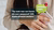 Photograph of woman holding smartphone with green chat bubble reading Dutch job offer text.