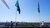 Two people are raising a flag to mark the completion of the highest point in the renovation of the Tinbergen Building.