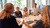 Photograph of five people in a conference room around a table, one woman gesturing.