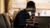 A man holding his head on a sofa with an overlay of a sociale media website