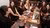Students smiling and talking around a restaurant table with drinks.