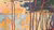 Paul Signac's painting consisting of uncountable dots, showing a coast scene with high, slim tress in the forewground and sailing boats on a sea in the background. The colours are vivid red with misty blue and yellow
