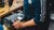 Photograph of hands using a power drill on a cylindrical motor housing on a workbench
