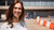 Smiling woman in white outfit standing at an outdoor construction site with barriers