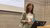 Woman in green blazer speaking at podium in concrete lecture hall.