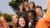 Photograph of seven young adults smiling for a group selfie outdoors.