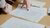 Hands pointing at sketches and notes spread across a wooden table