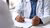 Doctor in white coat writes on clipboard at desk, stethoscope nearby