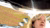 Curly blonde woman with dangling earrings gazes upward under reflective patterned canopy.