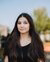 female student with brown hair in black t-shirt posing for the camera