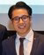 Axel HImawan dressed in a suit and tie smiling at the camera