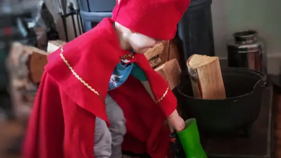 Jongetje verkleed als Sinterklaas zet laarsjes voor de kachel