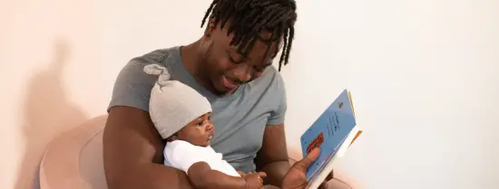 Een jonge vader leest baby voor uit prentenboek