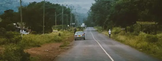 An empty road with one card parked on the side of the road in Tanzania