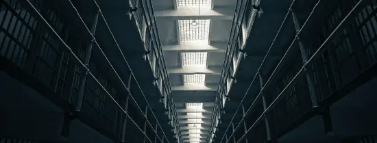 A frog perspective of the inside of a modern prison block, specifically depictions the rows of cells