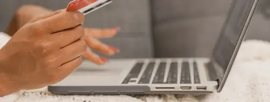Online shopper achter laptop met creditcard in de hand