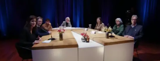 Seven people sitting around a white table