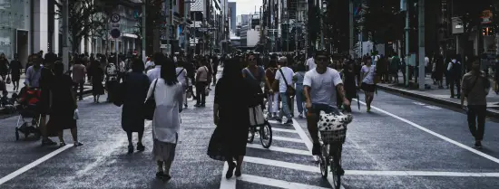People walking and biking on a wide street