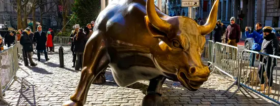 A statue of a bull on brick pavement