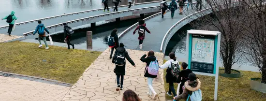 Primary school children running over the bridge on campus Woudestein
