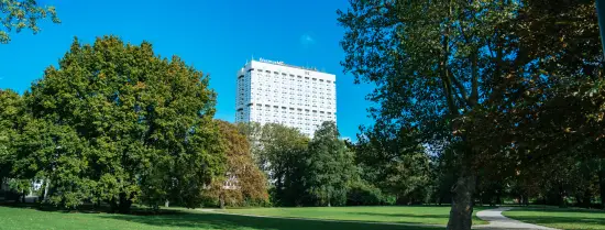 Een groen park met het ziekenhuis Erasmus MC op de achtergrond.