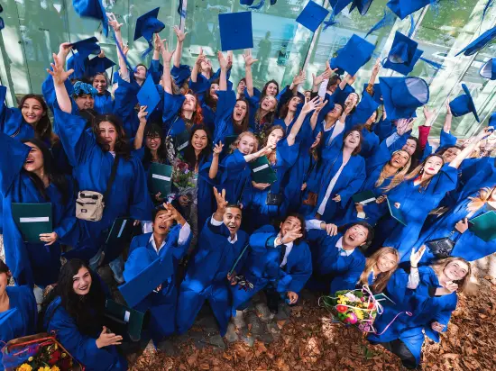Group of ESHCC alumni throwing their caps in the air