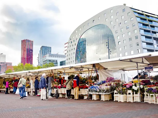 Mensen naast een bloemenkraam op de markt, vlakbij de Markthal in Rotterdam