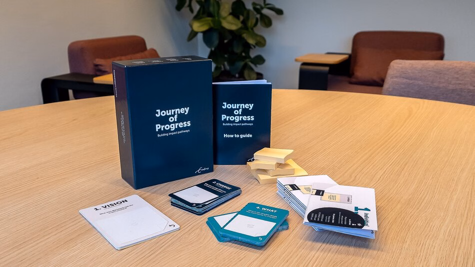 The Journey of Progress card set is displayed on a table.