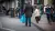 A man walks around with an Albert Heijn bag at a tram stop.