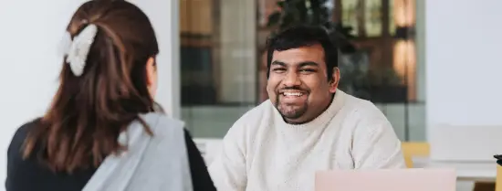 Student smiling at EUC with laptop