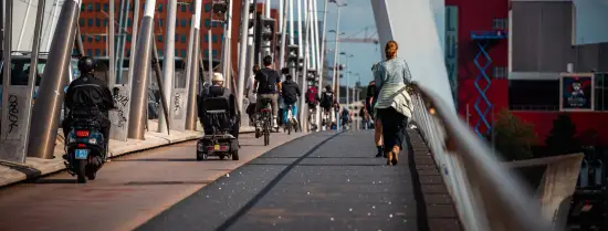 Mensen lopen en fietsen over de Erasmusbrug.