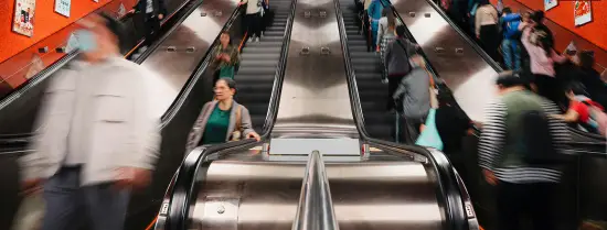 Group of people riding down an escalator